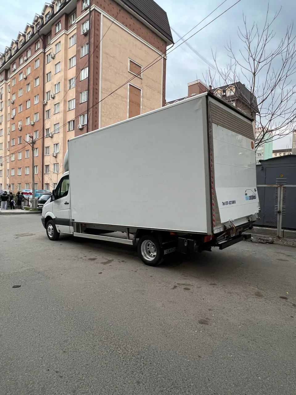 Белый грузовой фургон с закрытым кузовом на городской площадке